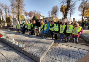 Nauczyciel stawia znicz na pomniku ofiar II wojny światowej